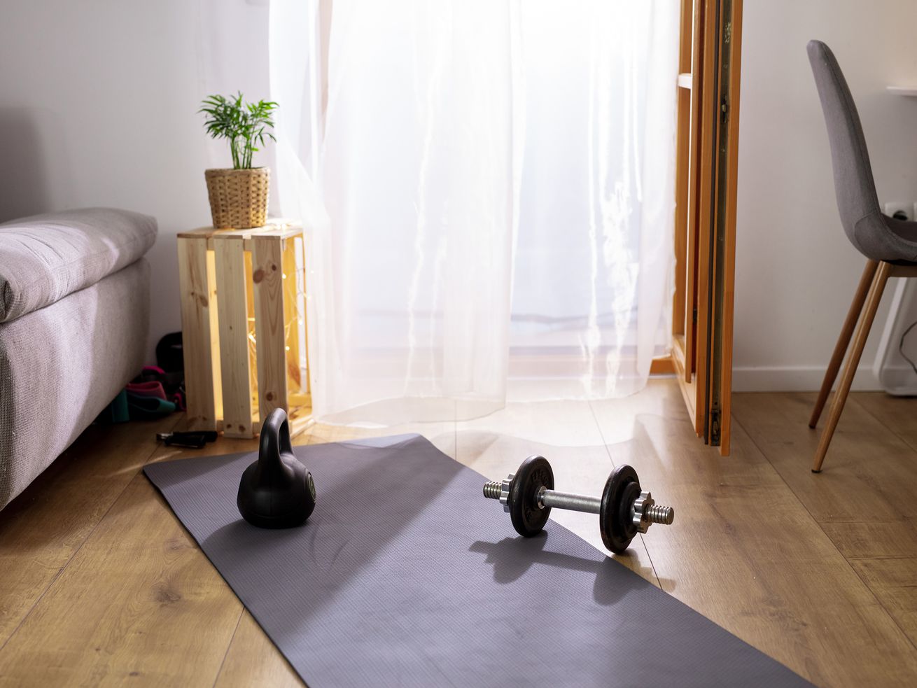 A yoga mat with weights set up in a living room. 