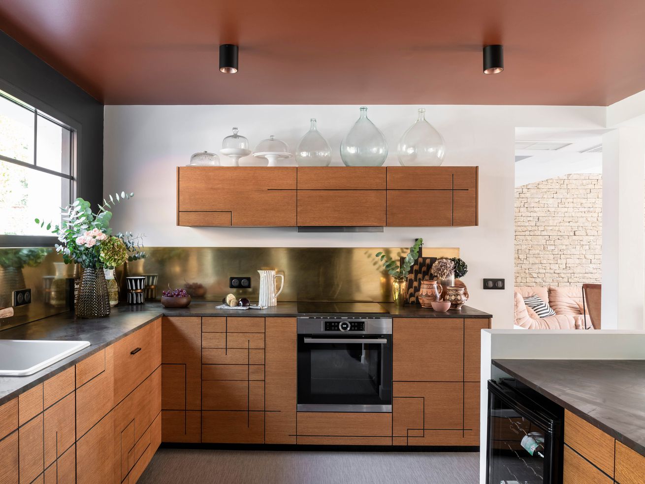 A modern kitchen with a clay colored ceiling. 