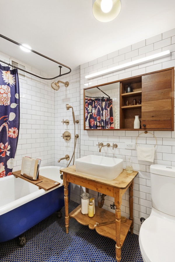 Image of a renovated bathroom with white subway tile and clawfoot tub