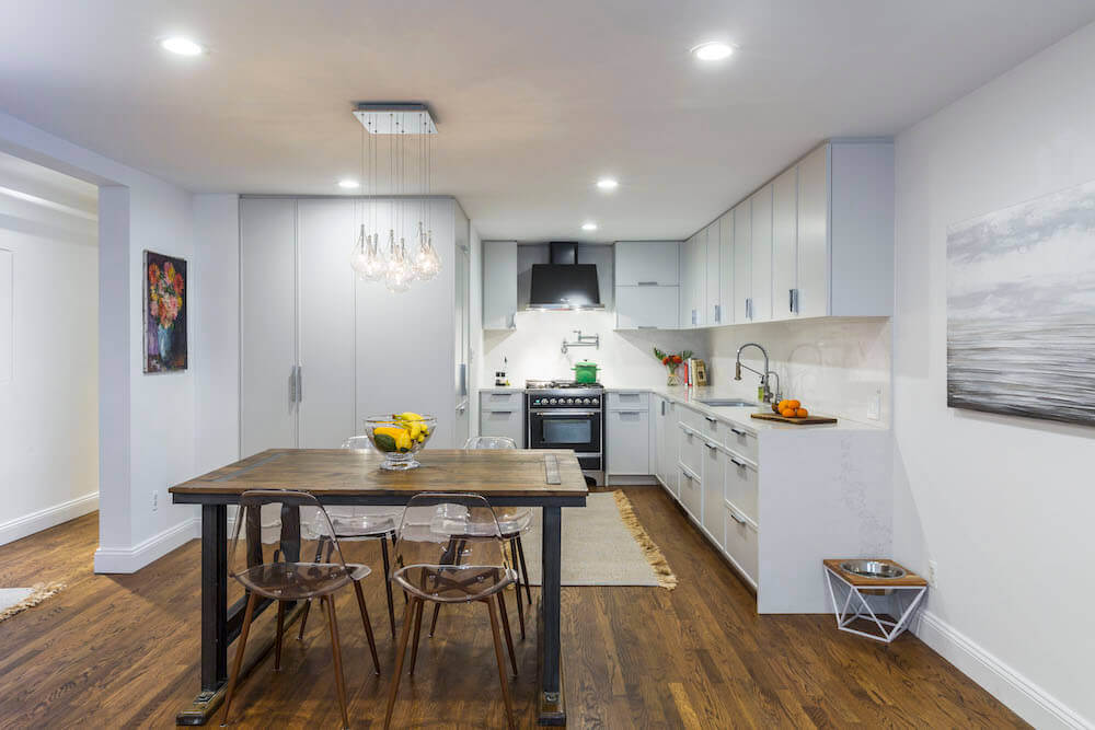 Image of a renovated kitchen with white kitchen cabinets and dining area