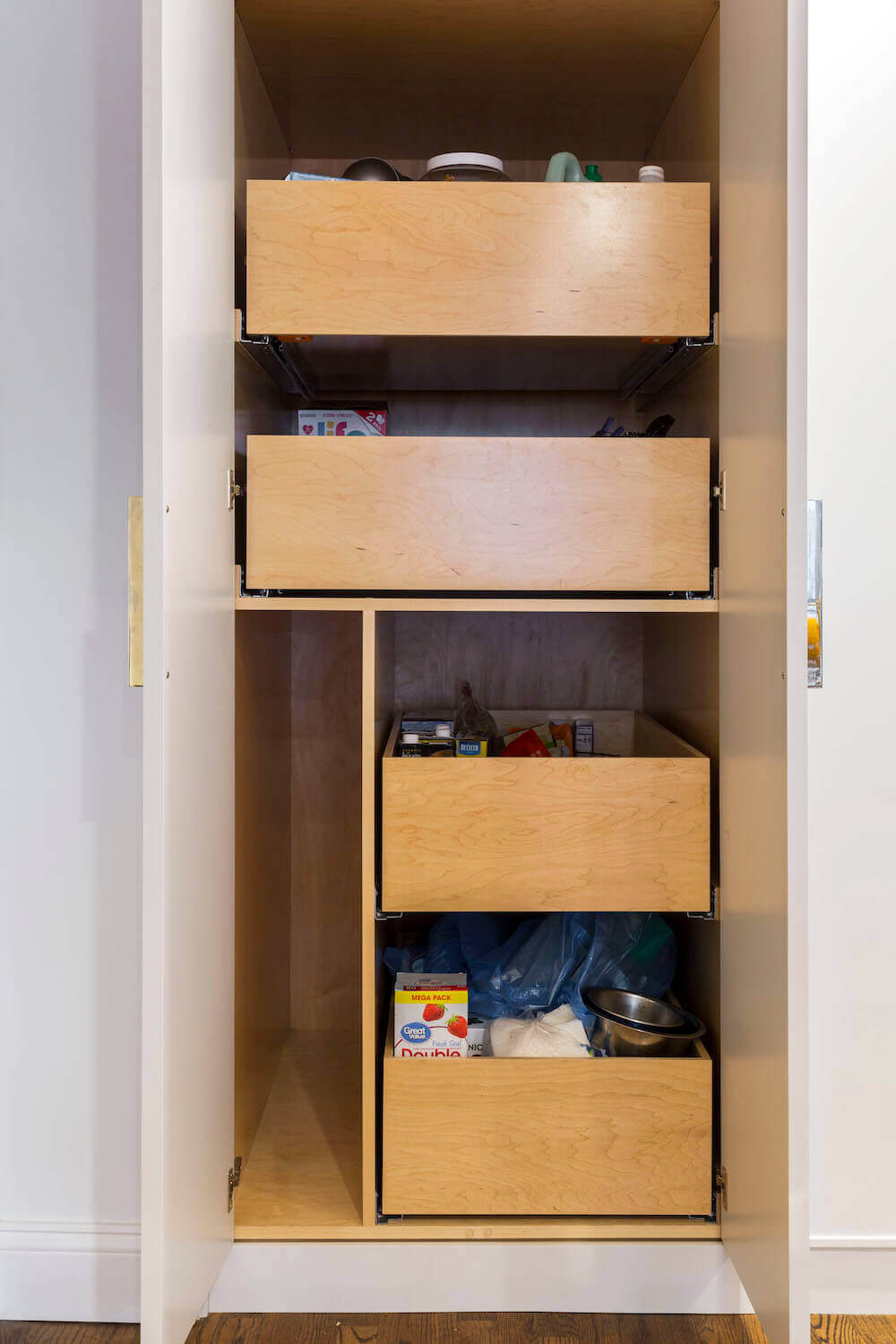 Image of an open kitchen cabinet with wooden pull-out drawers