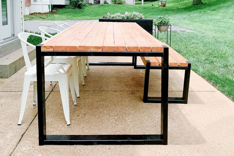 A handmade DIY table sits on a back patio.