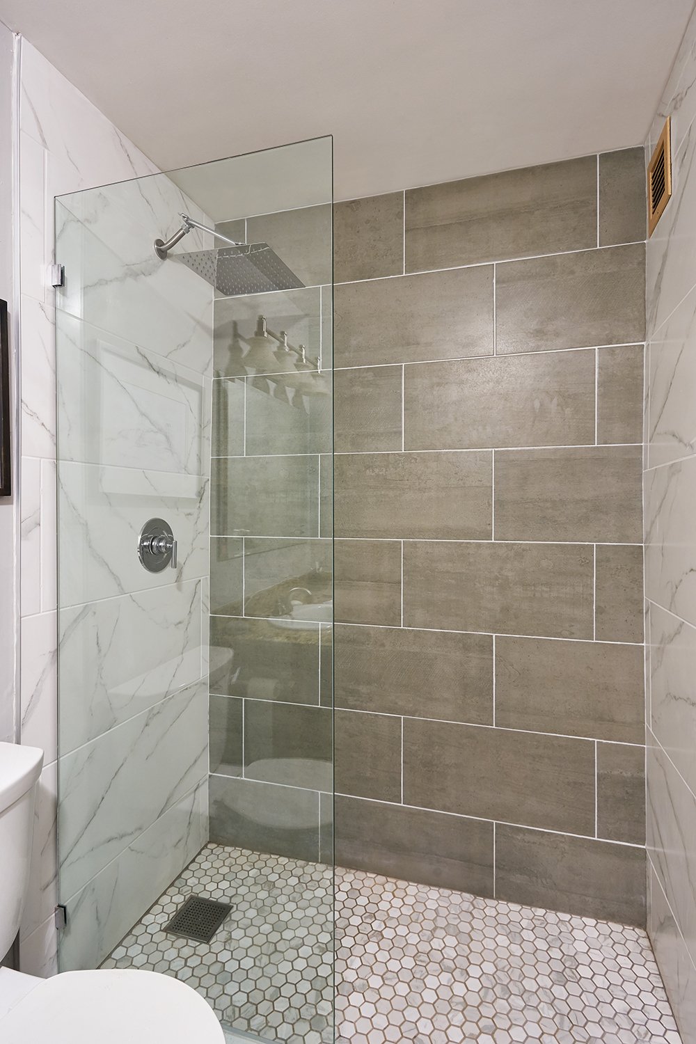 Bathroom shower with gray oversized tile and rainhead shower head