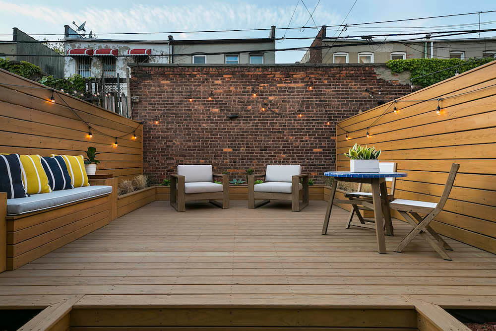 Image of a backyard remodel with bench seating and wood walls