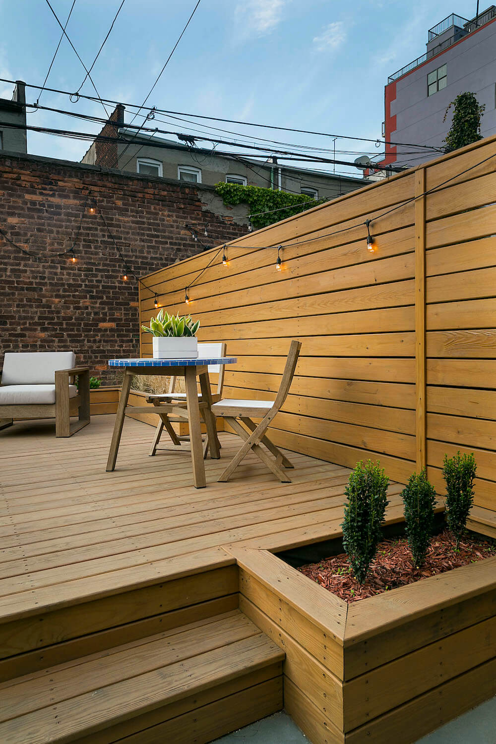 Image of a renovated backyard with wooden walls and built-in planters