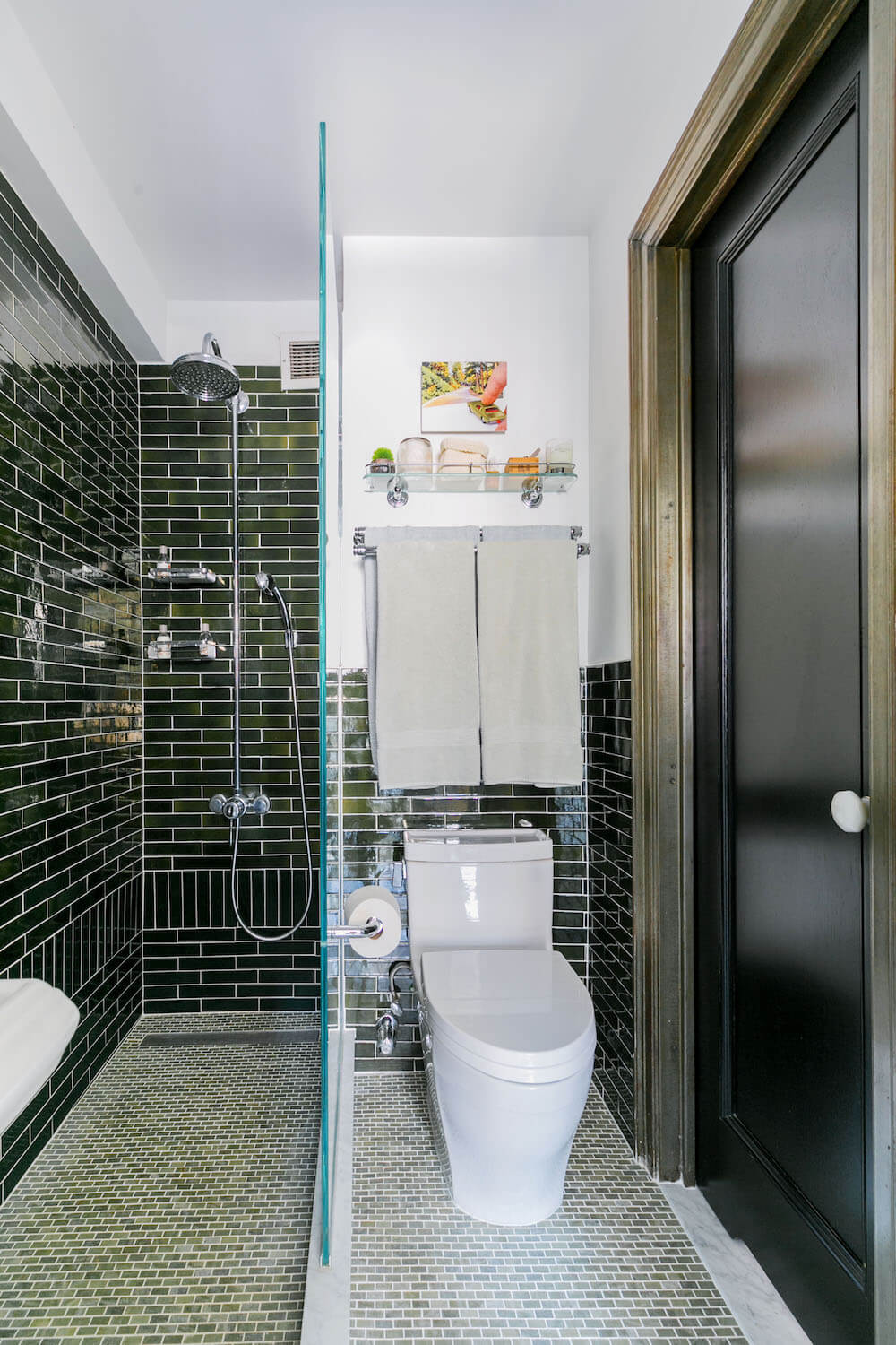 Image of a toilet in green tiled bathroom