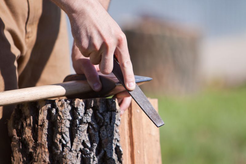 Sharpening an axe with a file