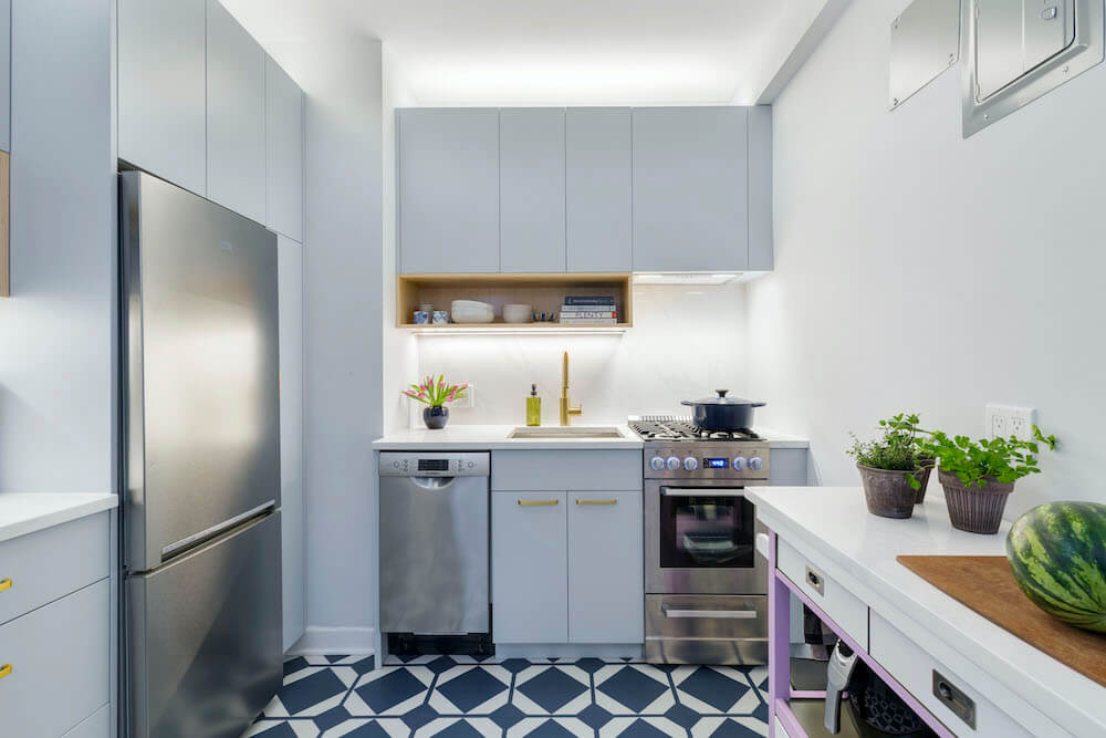 Image of a kitchen with patterned floor tile and blue cabinets