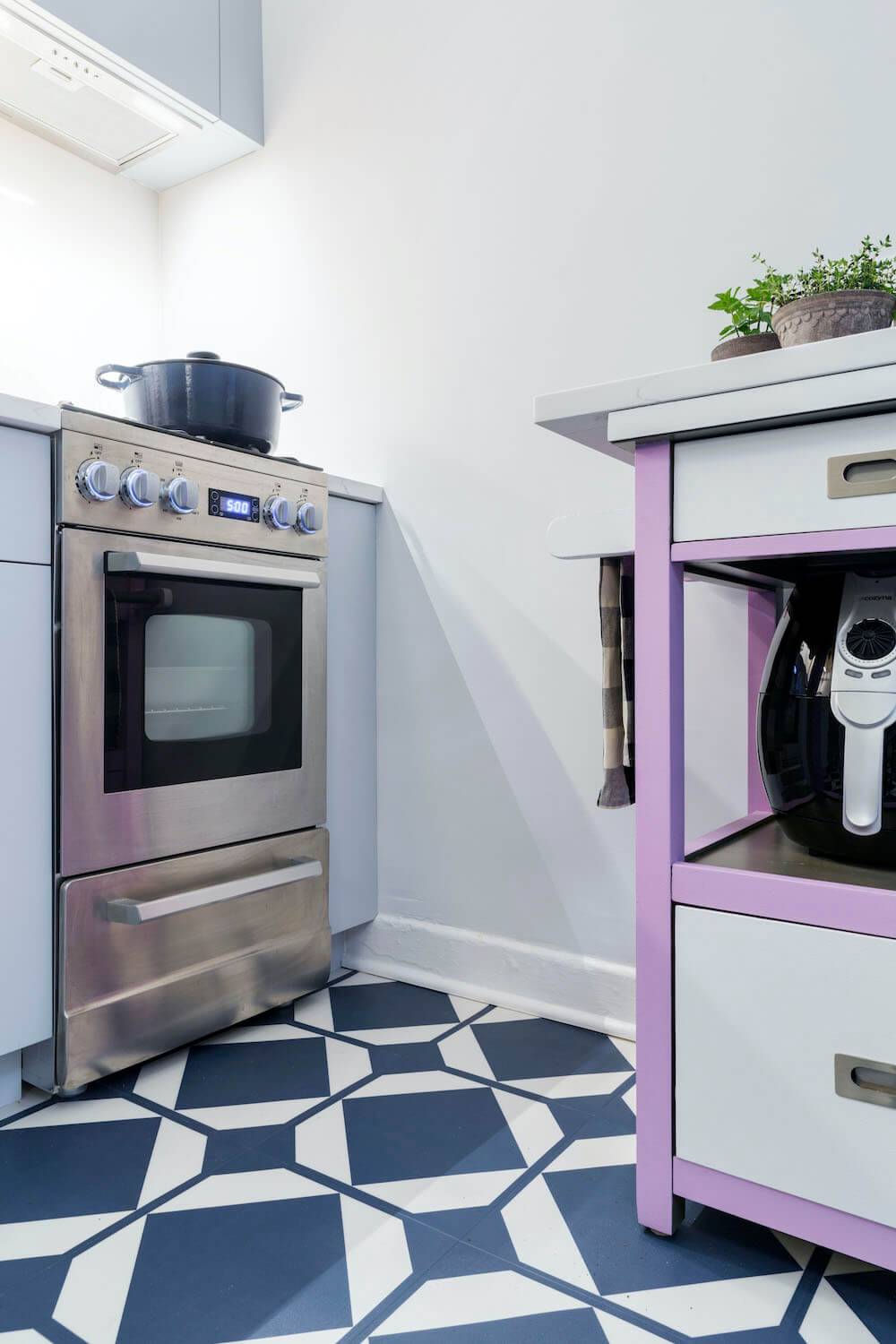 Image of a renovated kitchen with small stove and pattern floor tile