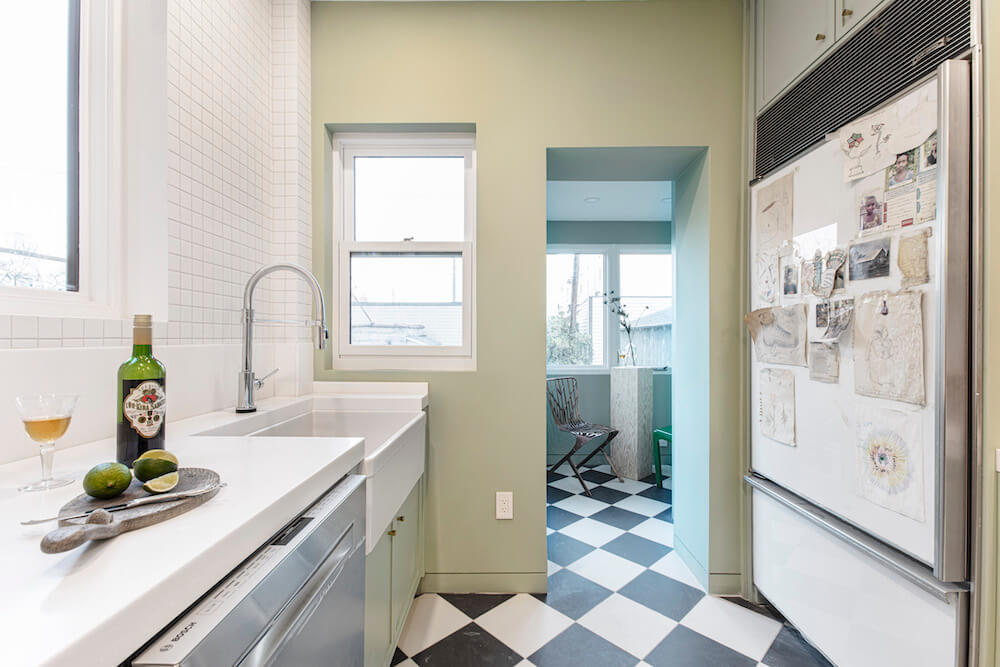 Image of a newly renovated kitchen with green walls and farmhouse sink