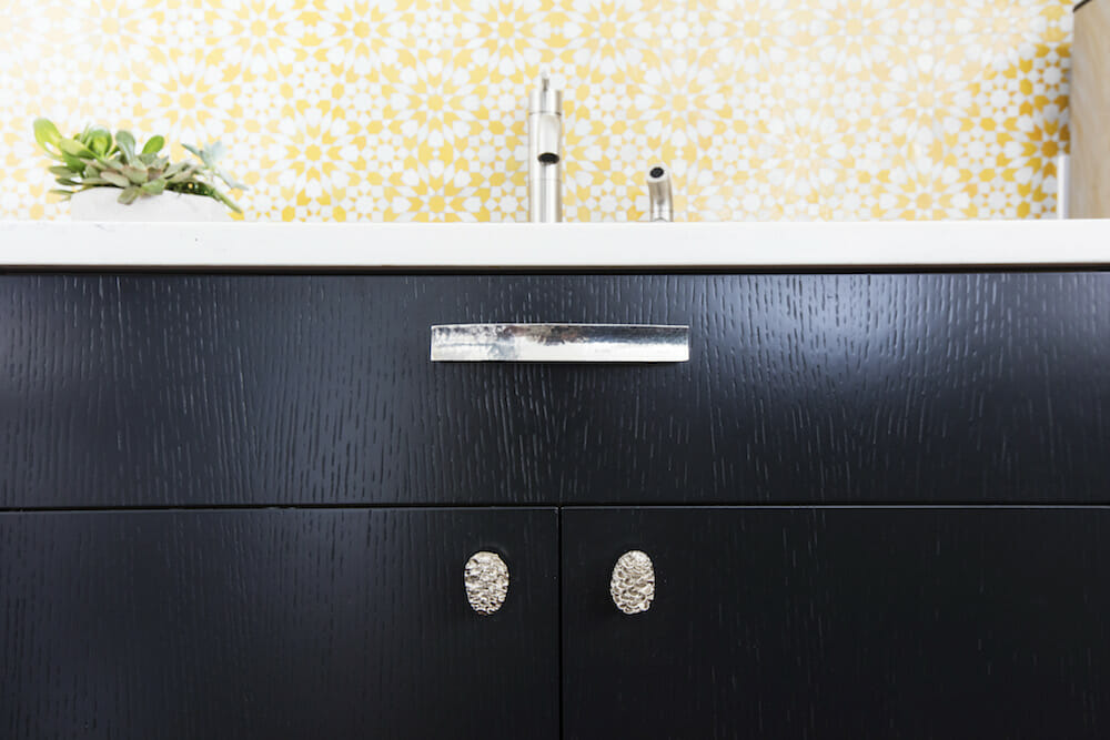 Image of a closeup black cabinet with silver cabinet handles