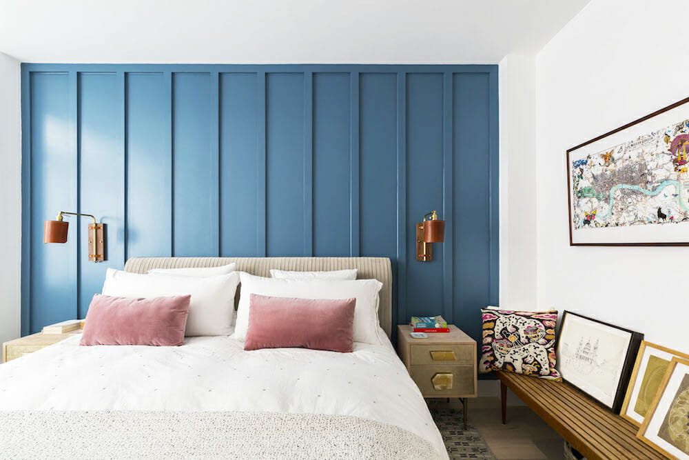 master bedroom with blue paneled accent wall behind bed