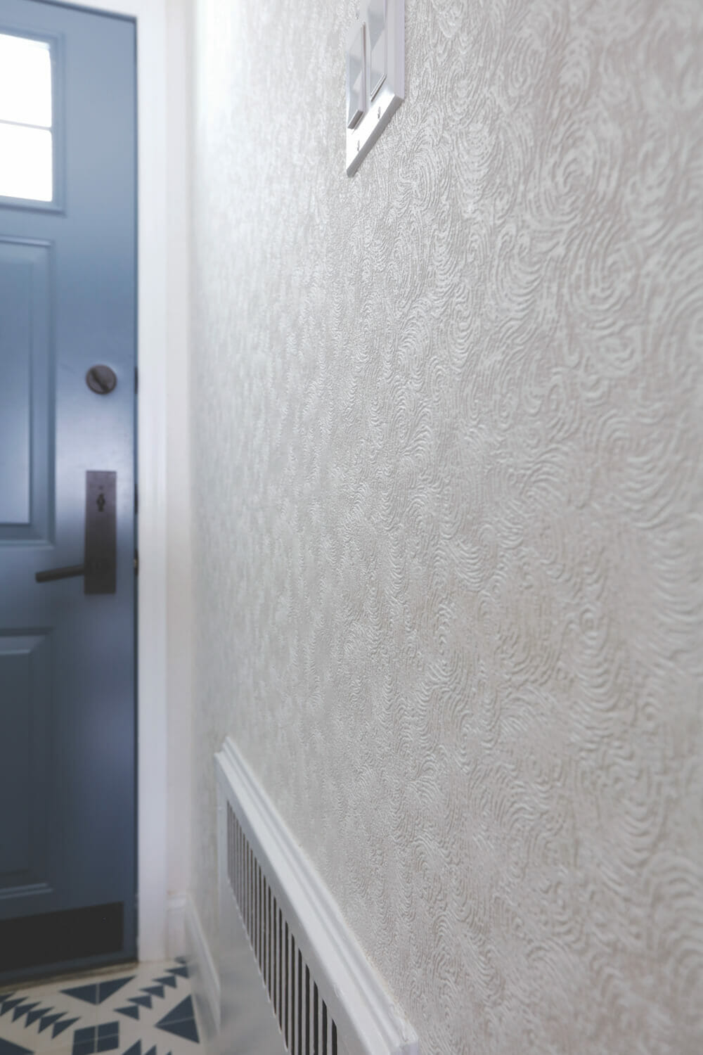 Image of closeup textured white wallpaper in entryway