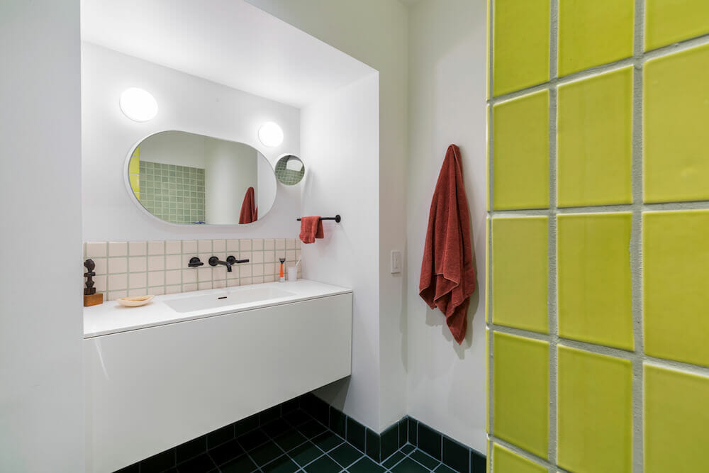 Image of a modern bathroom vanity and wall with green tile