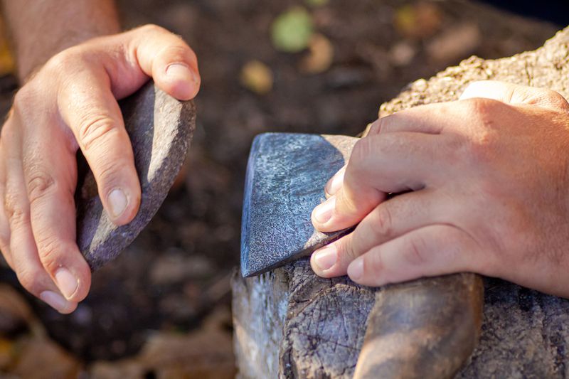 Sharpening an axe with a stone