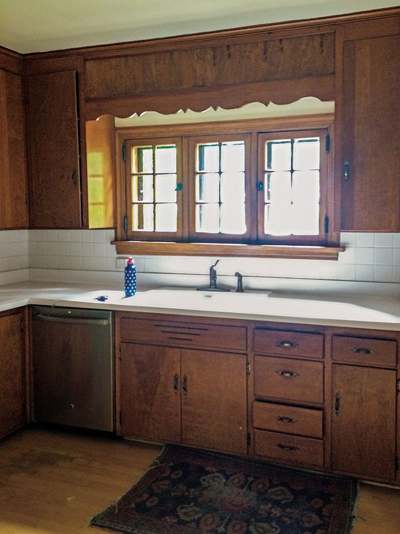 Relics from the 1960s, slab-front maple cabinets stained a dark, orangey-brown closed in the small space. White laminate counters and basic ceramic tiles were equally dated. 