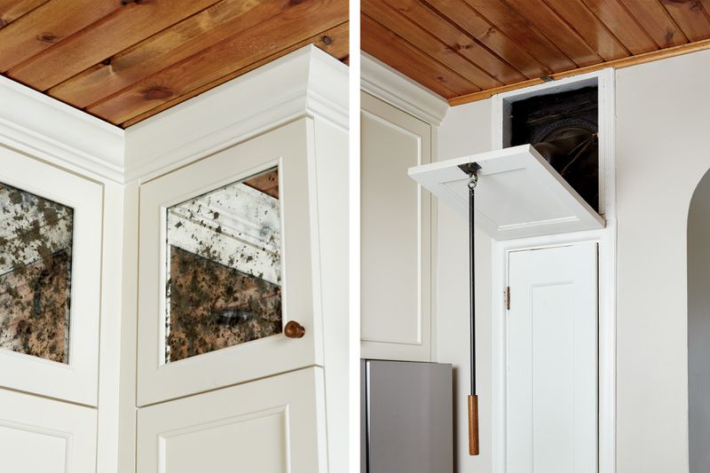 The doors on the uppermost cabinets to the left of the sink are inset with antiqued mirrors to help bounce light around the room. The glossy clear coat on the ceiling adds another reflective surface. Right: Newly refurbished, the kitchen’s original exhaust fan turns on automatically when the door is opened with an oak-handled iron hook. “It has a pretty strong draw so it can clear out cooking fumes,” says Rachel. 