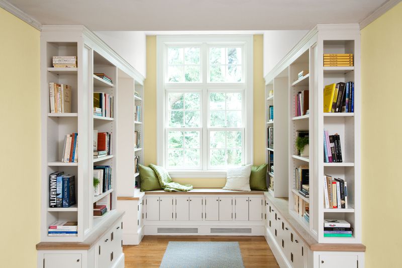 A home library with a large window as the focal point.