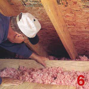 Person checking attic insulation.